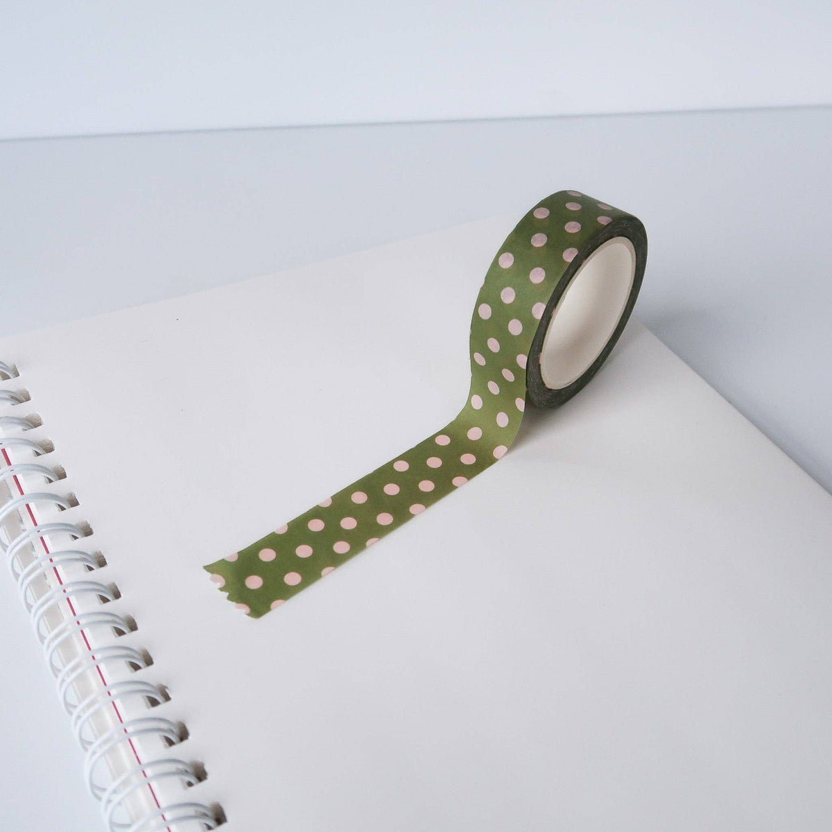 Green washi tape with pink dots on a notebook