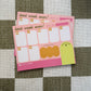 A pink weekly planner notepad with the phrase 'best week ever!' and a weekly grid, photographed on a brown and white checkered fabric background. The brand name 'LITTLE WINS' is visible in the bottom left corner.