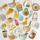 A collection of cute, die-cut sticker designs featuring various food items and food-themed illustrations, including sushi, pizza, fries, avocado, ice cream, pasta, and bubble tea, arranged on a light gray background.