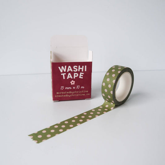 Green washi tape with pink polka dots and packaging on a white background